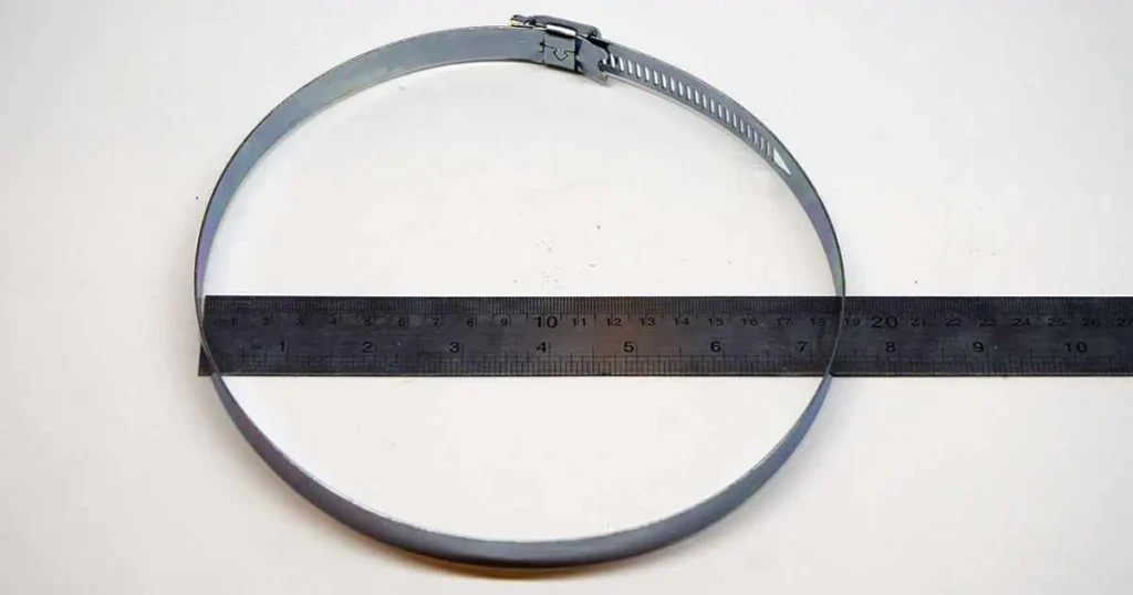 A circular metal ring with a ruler placed on top, measuring 8 inches long in diameter of A-25 belt specifications.