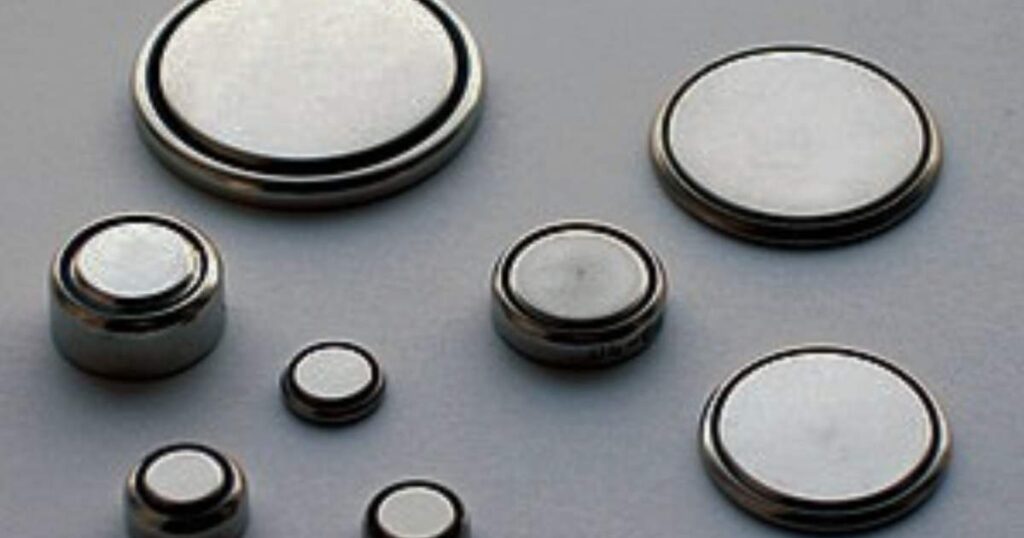 Close-up of two 2mm watch cells, highlighting their precision engineering and small dimensions against a neutral backdrop.
