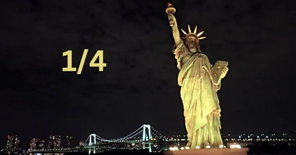 The 80 feet long ¼ Statue of Liberty illuminated at night, showcasing its grandeur against the dark sky.